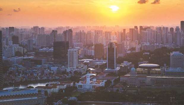 Buildings stand in the central business district as the sun sets in Singapore.