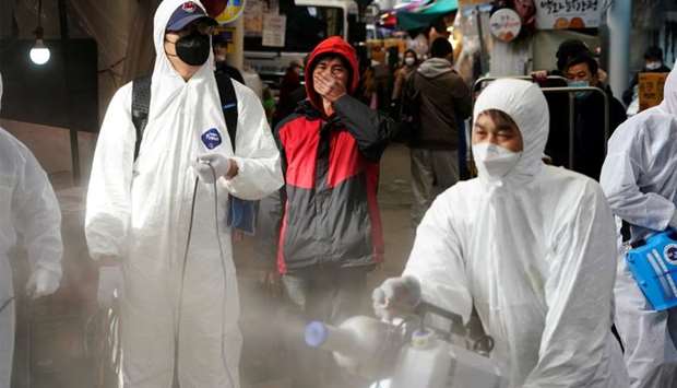 A man reacts as employees from a disinfection service company sanitize a traditional market in Seoul