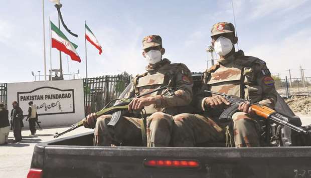 Soldiers wearing face masks are seen near the closed Pakistan-Iran border in Taftan.
