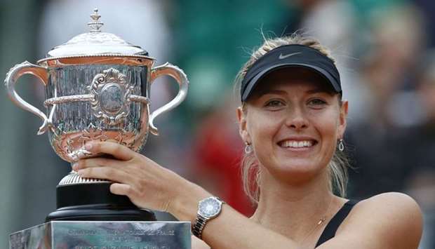 Maria Sharapova holds a trophy after winning over Italy's Sara Errani during their Women's Singles final tennis match of the French Open tennis tournament at the Roland Garros stadium, in Paris on June 9, 2012
