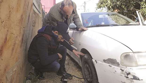A man checks his slashed tyre in the occupied West Bank village of Yasuf near Nablus, yesterday.