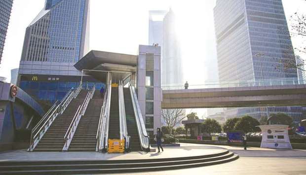 FILE PHOTO: People wearing masks are seen at Lujiazui financial district in Pudong, Shanghai, China, as the country is hit by an outbreak of a new coronavirus, on February 3, 2020.