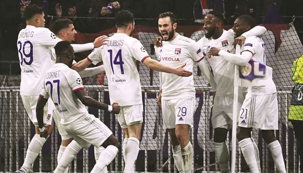 Lyonu2019s French midfielder Lucas Tousart (centre) celebrates with teammates after scoring a goal against Juventus during their Champions League last-16 tie. (AFP)