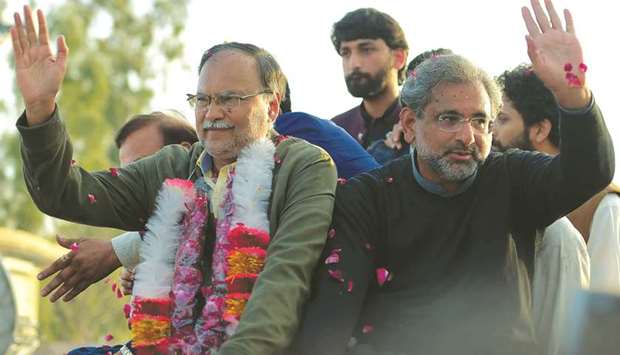 Pakistanu2019s former prime minister Shahid Khaqan Abbasi (right) and former interior minister and PML-N leader Ahsan Iqbal wave to supporters outside the Adiala prison after being granted bail, yesterday.