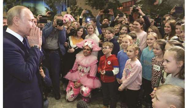 Putin with children from orphanages and low-income families during his visit to the Dream Island amusement park, ahead of its upcoming inauguration.