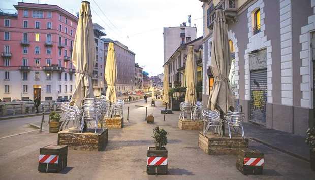 Seats are seen stalked outside a closed restaurant in Milan. Cafes and restaurants in the city of 1.3mn people were half empty, far fewer people than usual were using public transport and hotels reported a wave of cancellations yesterday.