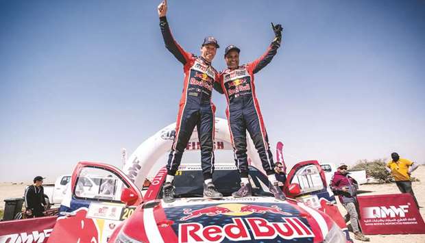 Qataru2019s Nasser Saleh al-Attiyah (right) and his French co-driver Mathieu Baumel celebrate their victory in the Manateq Qatar Cross-Country Rally yesterday.
