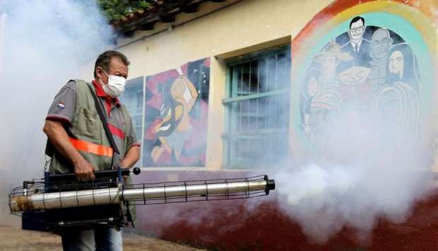 A federal health worker takes part in fumigation to prevent the proliferation of mosquitos that transmit the Dengue fever at the San Lorenzo National School, in a low-income neighbourhood of San Lorenzo, Paraguay on February 12, 2020