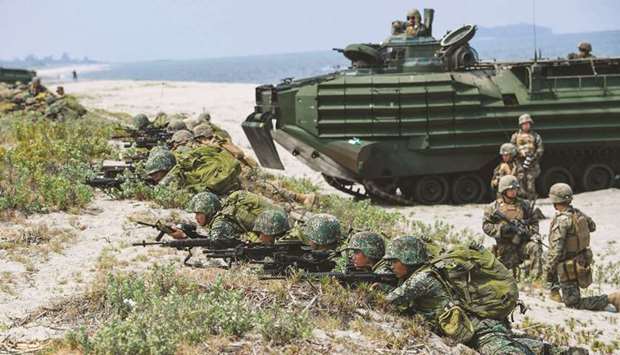 File photo taken on May 9, 2018 shows Philippines and US marines taking position next to assault amphibious vehicles (AAV) as they simulate an amphibious landing as part of the annual joint military exercise at the beach of Philippine navyu2019s training camp in San Antonio, Zambales province, northwest of Manila.
