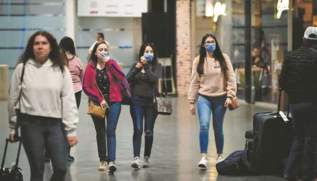 Passengers wear protective masks at Mexico Cityu2019s international airport yesterday.