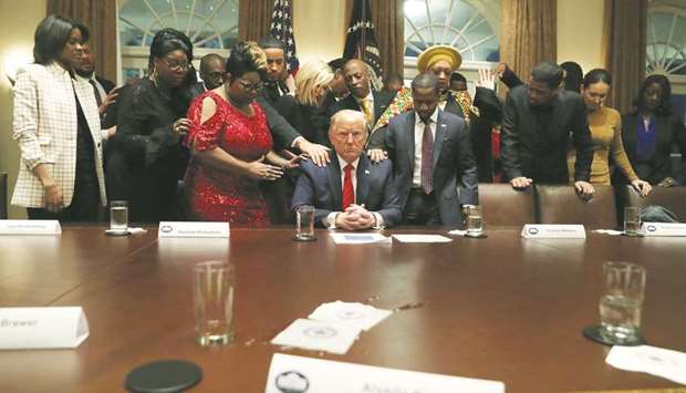 African-American supporters pray with US President Donald Trump in the Cabinet Room of the White House in Washington.