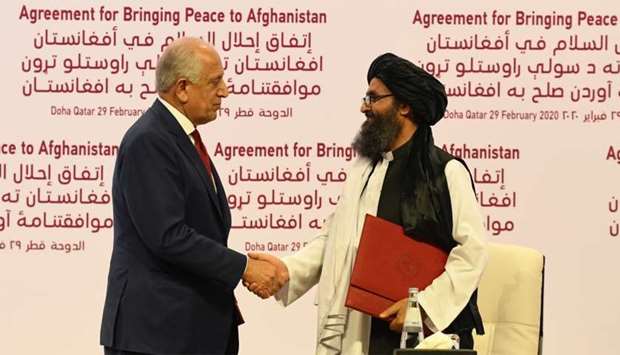 Khalilzad and Baradar shake hands after signing the agreement