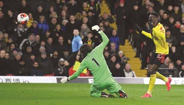 Watfordu2019s Senegalese midfielder Ismaila Sarr (right) scores his teamu2019s second goal past Liverpoolu2019s Brazilian goalkeeper Alisson Becker during the English Premier match at Vicarage Road Stadium in Watford, north of London, yesterday. (AFP)