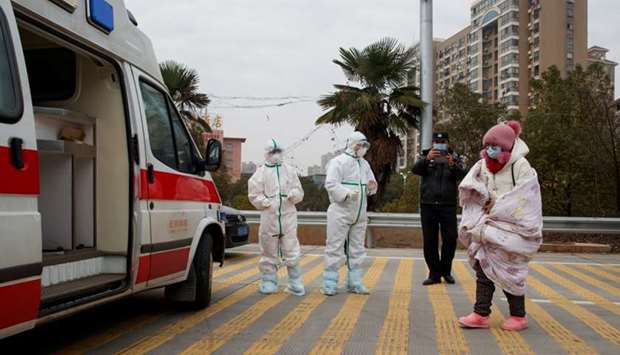 Hospital staff in protective garments pick up a leukaemia patient who arrived from the Hubei province exclusion zone at a checkpoint at the Jiujiang Yangtze River Bridge in Jiujiang, Jiangxi province, China