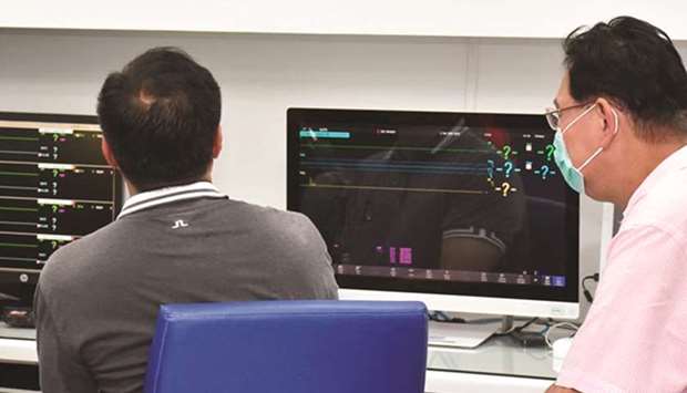Health Minister Anutin Charnvirakul (left) viewing closed circuit video images in Bamrasnaradura Infectious Disease Institute in Nonthaburi outside Bangkok where patients infected with Sars-like virus are confined.