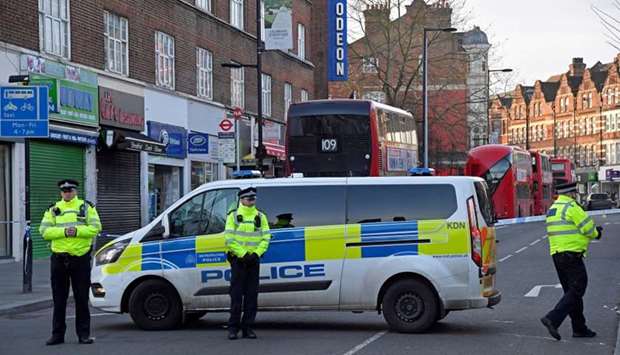 Police officers are seen near the site where a man was shot by armed officers in Streatham, south London, Britain