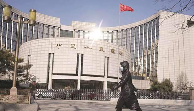 A pedestrian walks past the Peopleu2019s Bank of China headquarters in Beijing. The PBoC added a net 150bn yuan ($21.4bn) of funds yesterday using 7-day and 14-day reverse repurchase agreements.