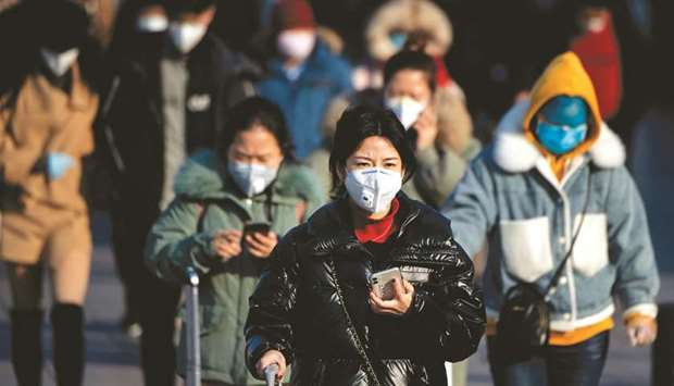 Travellers wearing face masks arrive from various provinces at the Beijing Railway Station yesterday. China said it urgently needed medical equipment and surgical masks as the death toll from a new coronavirus jumped above 360, making it more deadly than the Sars crisis nearly two decades ago.