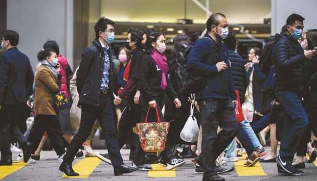 Pedestrians wear face masks as they cross a road in Hong Kong yesterday, as a preventative measure following a virus outbreak which began in the Chinese city of Wuhan.