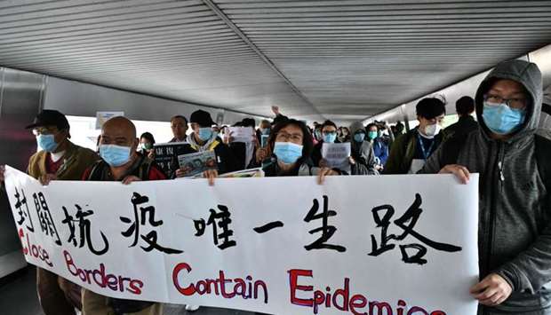 Protesters hold up banners and placards during a ,flash mob, gathering to demand the government close its border with mainland China to reduce the spread of the deadly SARS-like virus to Hong Kong