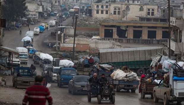 A convoy of trucks transporting Syrians and their belongings drives through the village of al-Mastuma, in the northern countryside of Syria's Idlib province on January 30.