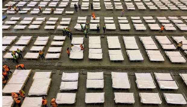 Workers set up beds at an exhibition centre that was converted into a hospital in Wuhan in China's central Hubei province. AFP
