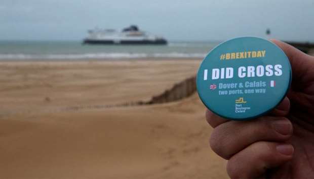 A man poses holding a badge made by the port of Boulogne Calais to mark Brexit day as P&O ,Spirit of Britain, leaves for the British port of Dover, in Calais