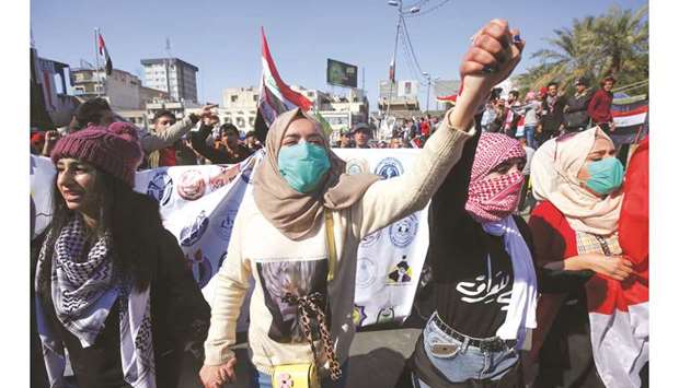Iraqi students hold hands and chant as they march in an anti-government demonstration in the capital Baghdadu2019s Tahrir square, yesterday.