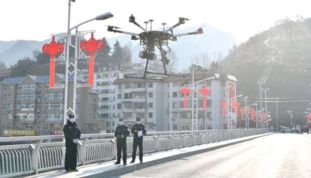 Police officers operate a drone to spread information about the prevention and control of the new coronavirus, in Baokang county, Xiangyang, Hubei province, China