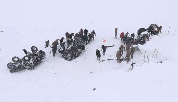 Turkish soldiers and locals try to rescue people trapped under an avalanche in Bahcesaray in Van province