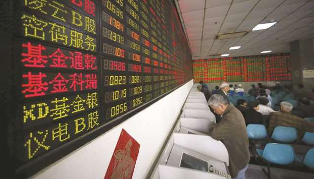 Investors look at computer screens showing stock information at a brokerage house in Shanghai. The Composite index closed up 1.3% to 2,818.09 points yesterday.