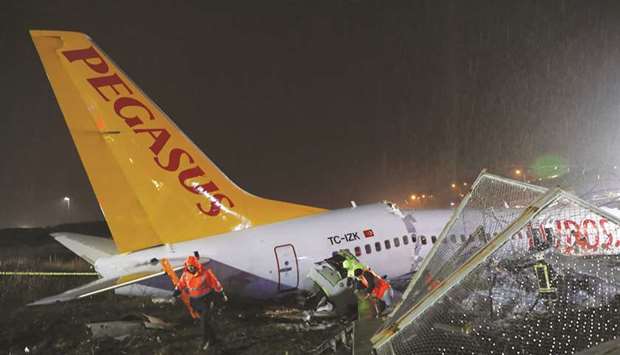 First responders walk at the Pegasus Airlines Boeing 737-86J plane crash site, after it overran the runway during landing, at Istanbulu2019s Sabiha Gokcen airport, Turkey yesterday.