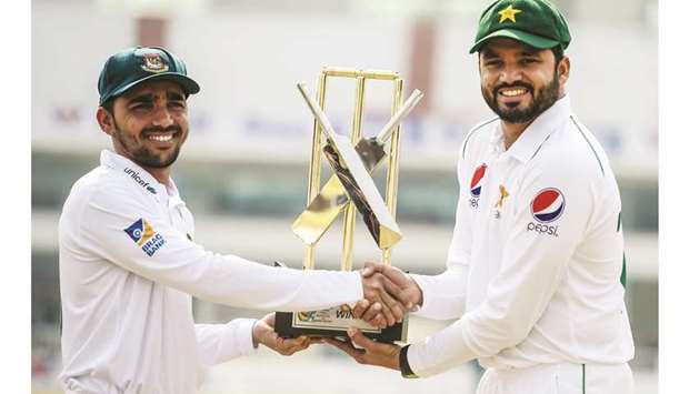 Pakistanu2019s Azhar Ali (right) and his Bangladesh counterpart Mominul Haque hold the Test series trophy at the Rawalpindi Cricket Stadium yesterday. (AFP)
