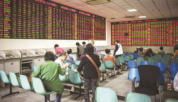 Investors sit in front of an electronic stock board at a securities brokerage in Shanghai. The Shanghai gauge closed up 0.3% yesterday after falling as much as 1%, while the ChiNext added 0.2%.