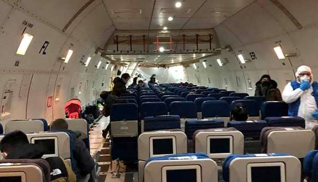 Passengers enter a cargo plane, chartered by the US State Department to evacuate Americans and Canadians from China due to the outbreak of novel Coronavirus, during the boarding process at Wuhan Tianhe International Airport in Wuhan yesterday