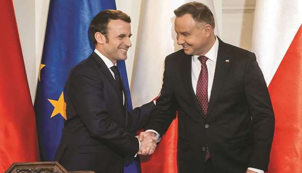 Macron and Duda shake hands after their joint press conference in Presidential Palace in Warsaw.