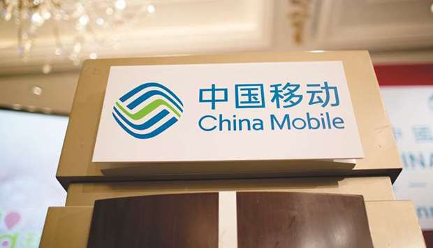 The China Mobile logo is displayed on a podium in Hong Kong. China Mobile and China Telecom fell more than 10% each in 2019 amid huge expenses for building their 5G networks and government mandates to keep a lid on the rates they charge.