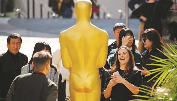 Fans crowd around an Oscar statue as preparation for the 92nd Academy Awards continued yesterday in Los Angeles.