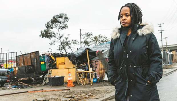 Carroll Fife, the director of the Oakland office for the Alliance of Californians for Community Empowerment, walks outside a homeless encampment in Oakland, California.