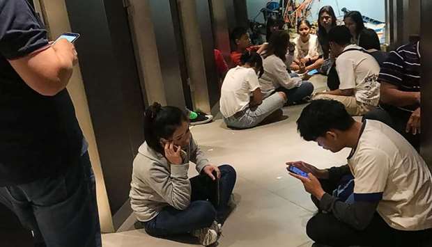 This handout from Chanathip Somsakul taken on yesterday and released to AFP, shows people sitting in the Terminal 21 shopping mall in Nakhon Ratchasima as they wait to be evacuated to a safer area following a shooting incident in the mall