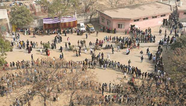 People queue at a polling station to cast their votes during the assembly elections in New Delhi yesterday.