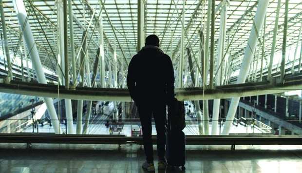 A traveler stands with his luggage at the Charles de Gaulle airport, operated by Aeroports de Paris, in Roissy, France. Since the first appearance of these new variants, many countries have reported a higher rate of spread and responded by putting further restrictions on international travel.