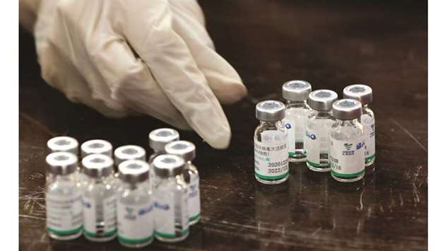 A health worker counts used vials of Sinopharmu2019s coronavirus disease (Covid-19) vaccine, at a vaccination centre in Karachi.
