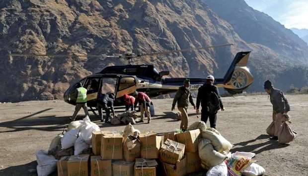 People load relief goods onto a helicopter for distribution in the affected areas, after a flash flood swept a mountain valley destroying dams and bridges, in Dhak village in Chamoli district, in the northern state of Uttarakhand, India,