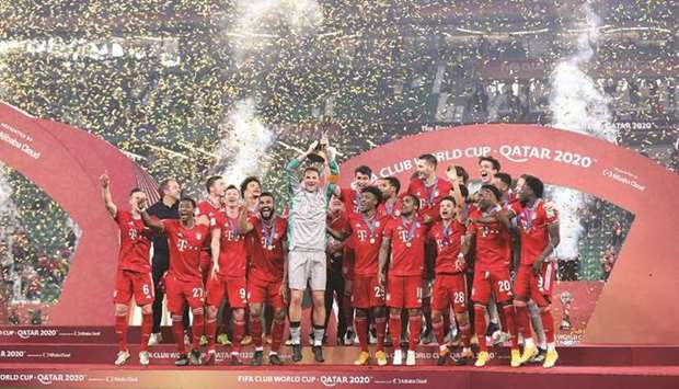 Bayern Munich captain Manuel Neuer lifts the FIFA Club World Cup trophy as his teammates celebrate at the Education City Stadium.