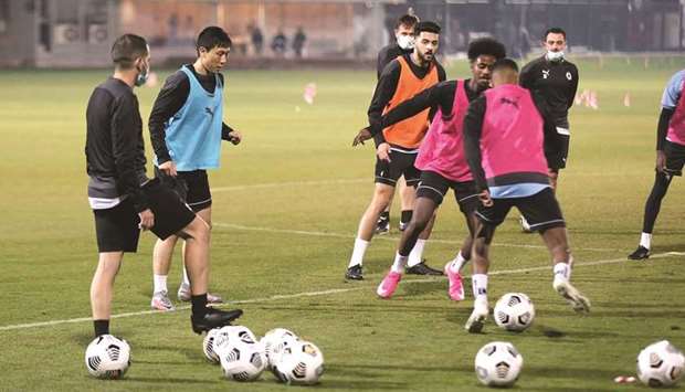 Al Sadd head coach Xavi Hernandez (right) watches his players take part in a training session yesterday.