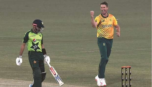 South Africau2019s Dwaine Pretorius (right) celebrates after taking the wicket of Pakistanu2019s captain Babar Azam (left) during the second T20 international at the Gaddafi Cricket Stadium in Lahore yesterday. (AFP)