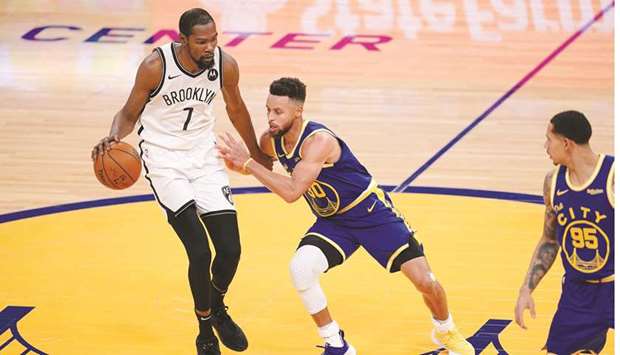 Brooklyn Nets forward Kevin Durant (left) dribbles the ball against Golden State Warriors guard Stephen Curry in the second quarter at the Chase Center in San Francisco. (USA TODAY Sports)