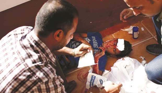 File photo taken on July 16, 2014 shows Palestinian journalists take care of a wounded boy following an Israeli military strike on the beach at Gaza Cityu2019s Al-Deira hotel.