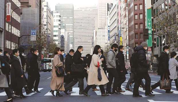 Pedestrians make their way during commuting hour at a business district in Tokyo. Japanu2019s economy expanded more than expected in the fourth quarter, extending the recovery from its worst postwar recession thanks to a rebound in overseas demand that boosted exports and capital spending.